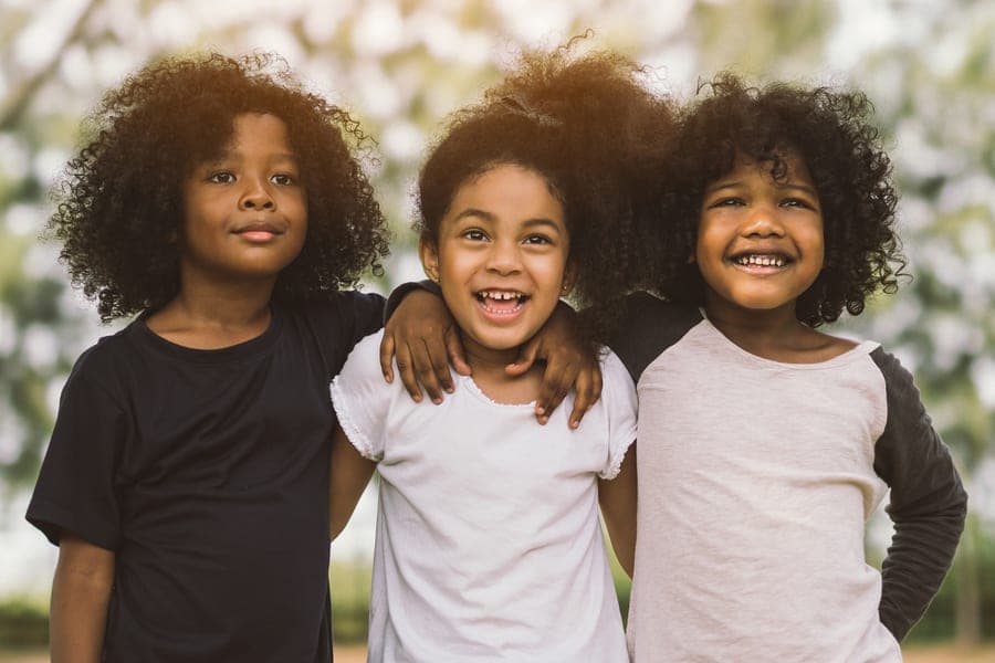 Three young friends smiling together