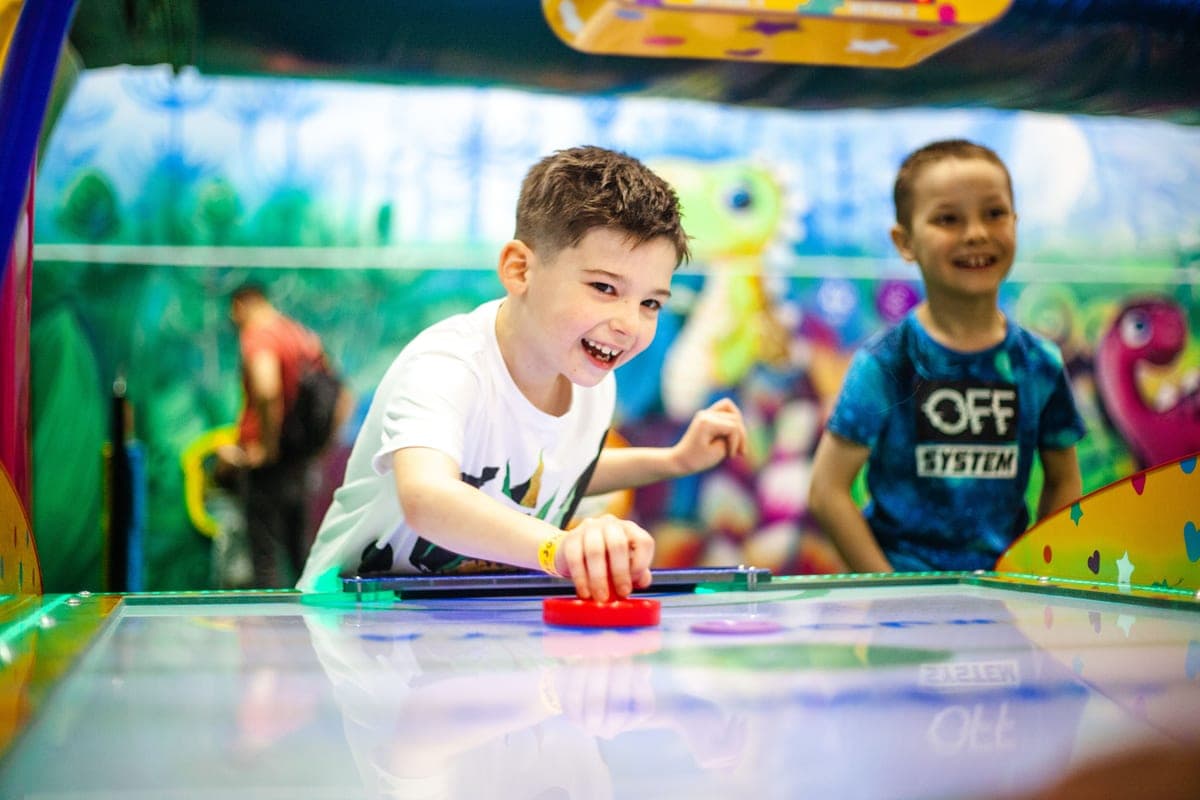 Kids playing air hockey during a KidsWow session